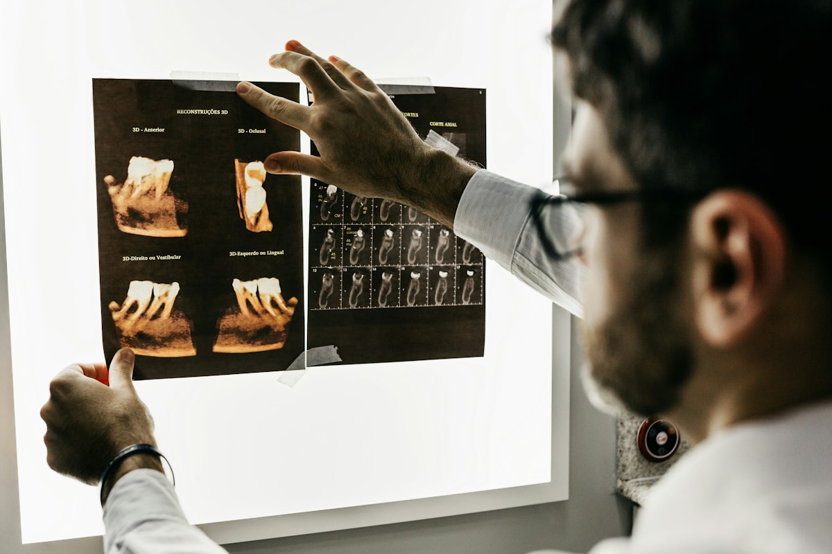 SmileCraft dentist reviewing dental implant scans and X-rays on a lightbox with a patient
